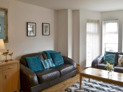 a living room with a leather couch and a table at Number 7 in Whitby