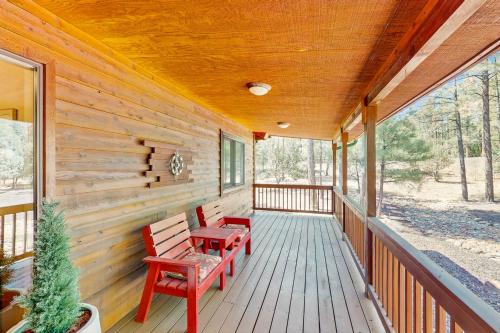 a porch with two benches and a table on it at Elk Run Escape in Show Low