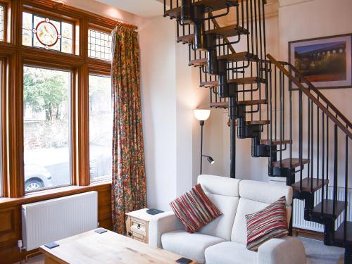 a living room with a couch and a spiral staircase at Inglewood Terrace in Penrith