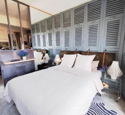 - une chambre avec un grand lit blanc et quelques fenêtres dans l'établissement ROMANTIC LOFT WITH COSY TERRACE - Nice, à Nice