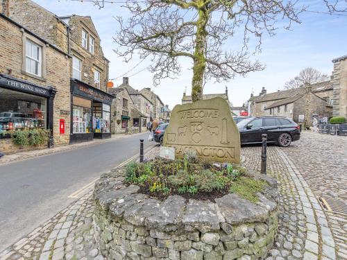a stone grave on the side of a street at Market Square in Grassington