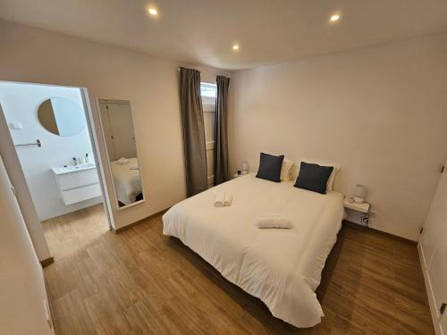 a bedroom with a white bed and a large mirror at Sun and Beach II AC Wifi 90mts from the Beach in Portimão
