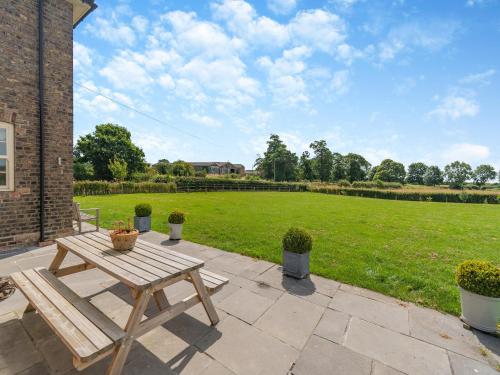 a picnic table on a patio with a field of grass at Farrington House in Lowthorpe