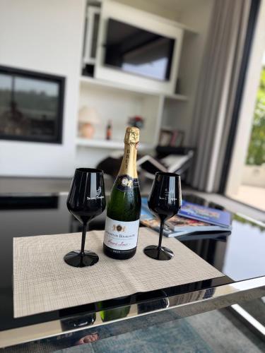 a bottle of wine sitting on a table with two glasses at Villa Hirondelles 35 in Cavalaire-sur-Mer