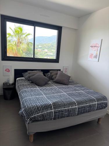 a bed in a room with a large window at Villa Hirondelles 35 in Cavalaire-sur-Mer