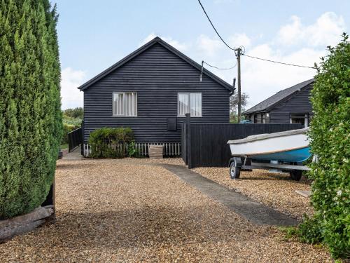 a boat parked in front of a house at Sunset Lodge in Brundall
