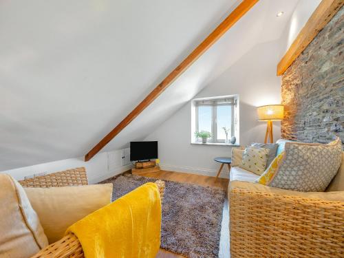 a living room with two couches and a stone wall at Horseshoe Cottage - Uk48252 in Downderry