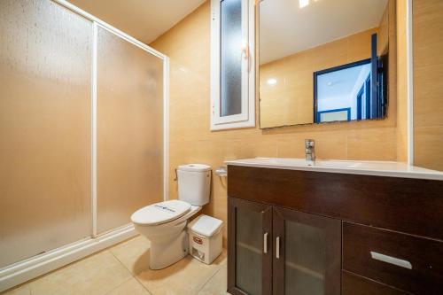 a bathroom with a toilet and a sink and a shower at Torrebaix in Torredembarra