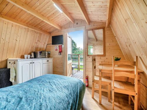 Dormitorio en cabaña de madera con cama y escritorio en Shadi - Uk45069, en Derwydd