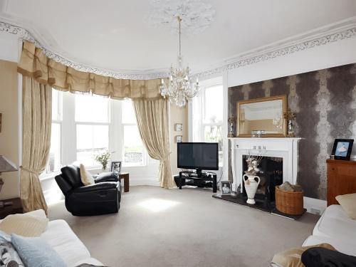 a living room with a fireplace and a television at Island Seaview Villa in Rothesay