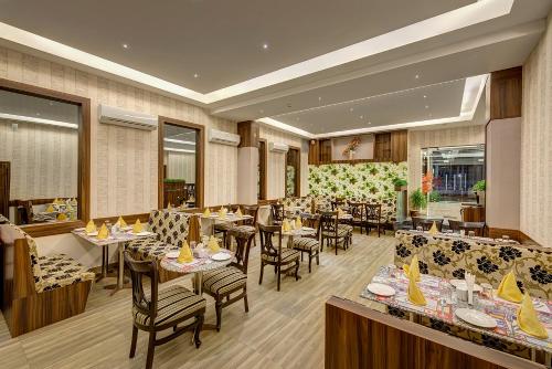 um restaurante com mesas e cadeiras num quarto em Viceroy Boutique Hotel em Calcutá