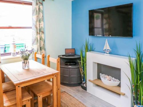 a living room with a table and a fireplace at Whitby Sands in Whitby
