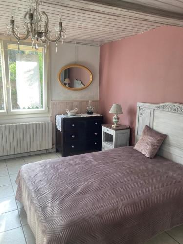 une chambre avec un lit et un miroir au mur dans l'établissement Maison Périgourdine de charme dans la campagne proche de Bergerac, à Saint-Nexans