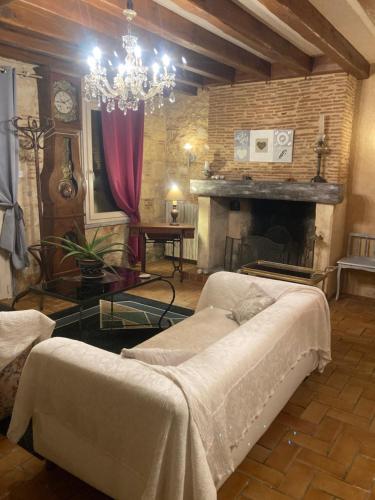 - un salon avec un lit et une cheminée dans l'établissement Maison Périgourdine de charme dans la campagne proche de Bergerac, à Saint-Nexans