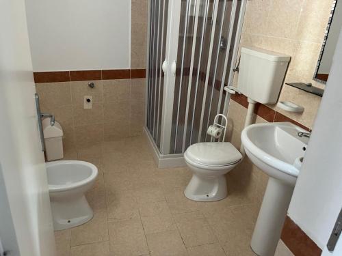 a bathroom with a toilet and a sink and a shower at B&B Pepebianco in Cariati