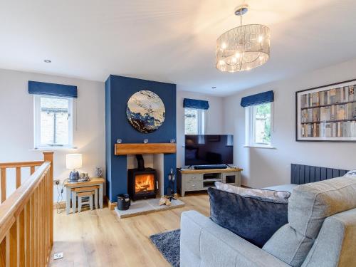 a living room with a couch and a fireplace at Lindale Cottage in Skipton