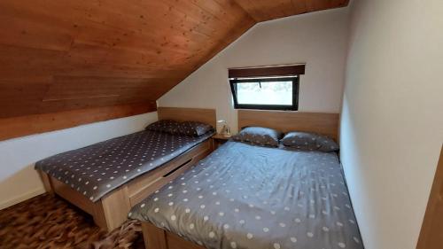 two beds in a small room with a window at Cabana 325 in Cinciş