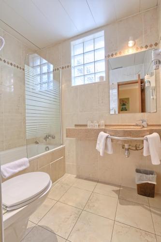 une salle de bain avec toilettes, lavabo et miroir dans l'établissement 121 Paris Hotel, à Paris