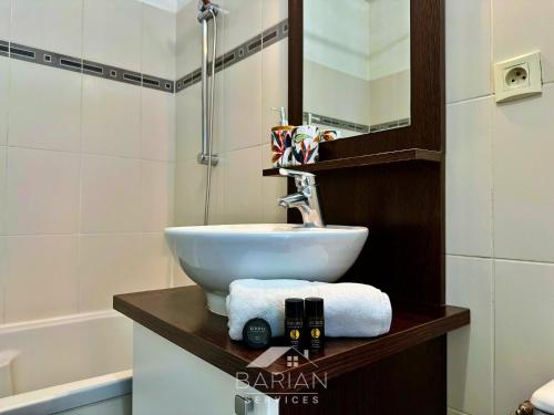 une salle de bain avec un lavabo et une baignoire dans l'établissement Appt Cosy avec balcon - Plage & commodités à pied - Linge et Ménage Fournis, à Aytré