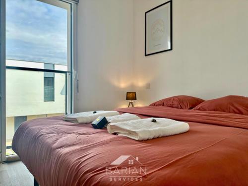 une chambre avec un lit avec des serviettes dessus dans l'établissement Appt Cosy avec balcon - Plage & commodités à pied - Linge et Ménage Fournis, à Aytré