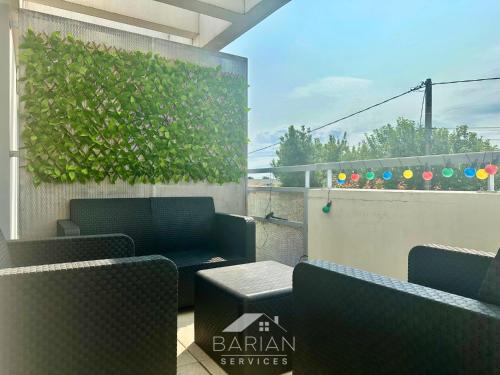 un balcon avec des chaises et une plante sur un mur dans l'établissement Appt Cosy avec balcon - Plage & commodités à pied - Linge et Ménage Fournis, à Aytré