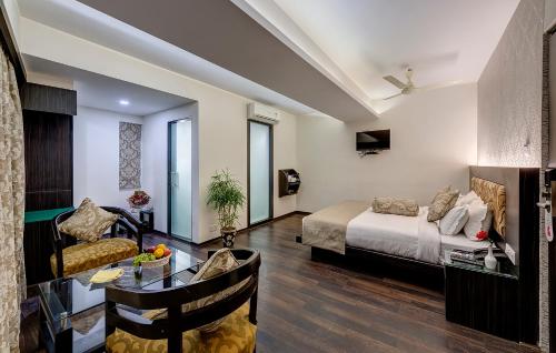a bedroom with a bed and a living room at Viceroy Boutique Hotel in Kolkata