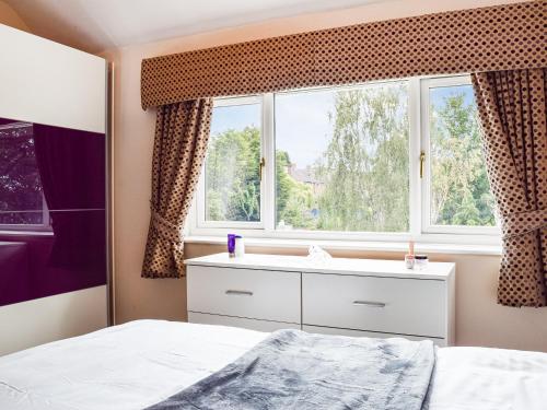 a bedroom with a bed and a window at Serenity Comfort in Sutton Coldfield