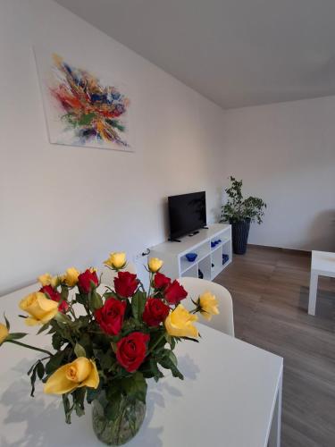 a vase filled with yellow and red flowers on a table at Villa Ivana in Koper