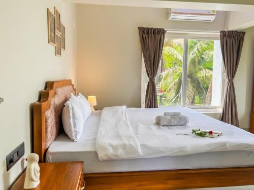 a bedroom with a large bed with a window at 5 Star Luxe 2BHK River View Apartment Porvorim in Porvorim