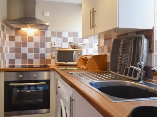 a kitchen with a sink and a stove at High Tide in Cellardyke