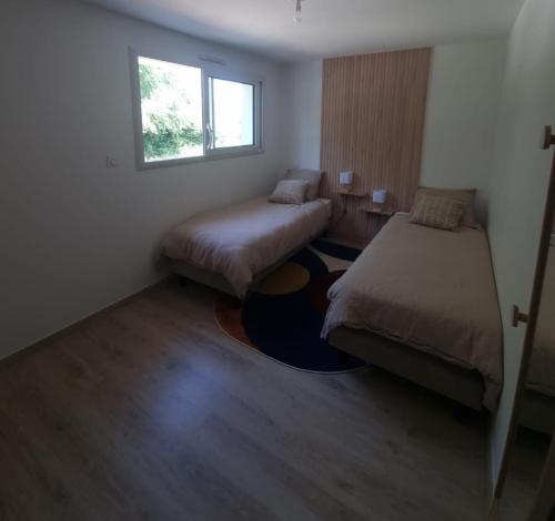 une petite chambre avec deux lits et une fenêtre dans l'établissement Maison Cosy T4 proche de la mer, à Saint-Brévin-lʼOcéan