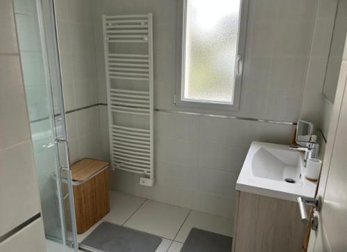 La petite salle de bains est pourvue d'une douche et d'un lavabo. dans l'établissement Maison Cosy T4 proche de la mer, à Saint-Brévin-lʼOcéan