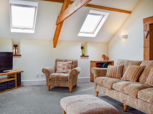 a living room with a couch and a tv at The Imaginary Barn in Hartland