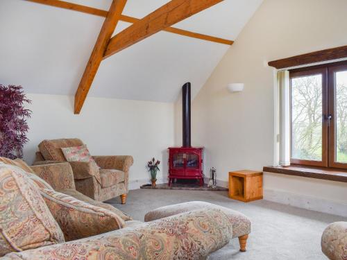 a living room with a couch and a wood stove at The Imaginary Barn in Hartland