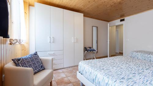 a bedroom with a bed and a chair at Casa Lateis 24 in Lateis