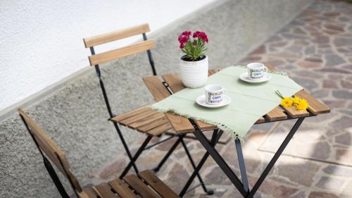 a small table with two cups and flowers on it at Casa Lateis 24 in Lateis