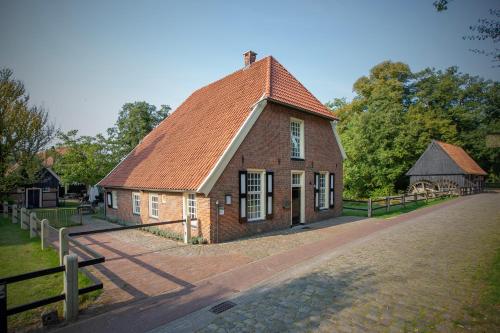 an old brick building with a roof on a street at Malle Mühle Bed & Breakfast in Lage