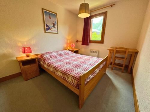 a bedroom with a bed and two tables and a window at Duplex classique 6 pers à 50m du télécabine, 2 chambres - FR-1-452-139 in Saint-Martin-de-Belleville