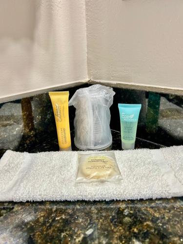 a shelf with two toothbrushes and two cups on a towel at Shining Light Inn & Suites in Kissimmee