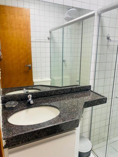 a bathroom with a sink and a mirror at Flat no Hotel Monte Castelo in Sairé