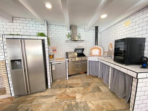 a kitchen with a stainless steel refrigerator and a stove at Chalet Albariza in Sanlúcar de Barrameda