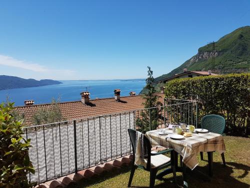 a table and chairs on a balcony with a view of the water at Residence Erika in Tignale