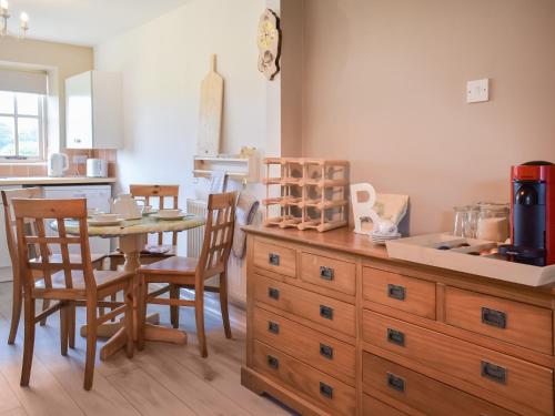 a kitchen with a table and a wooden dresser at The Cottage At Canefield Farmhouse in Southampton