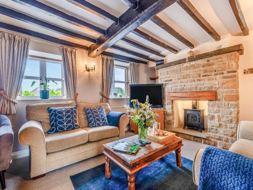 a living room with a couch and a fireplace at Perkins Cottage in Ashover