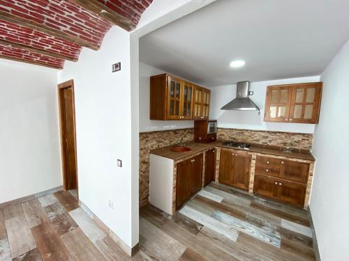 a kitchen with wooden cabinets and wooden floors at Chalet Albariza in Sanlúcar de Barrameda
