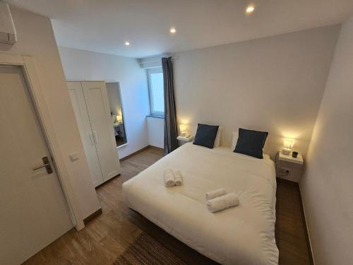 a bedroom with a white bed with two towels on it at Sun and Beach II AC Wifi 90mts from the Beach in Portimão