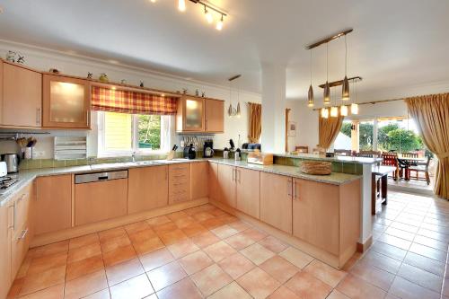 a large kitchen with wooden cabinets and a large island at Casa Alha in Carvoeiro