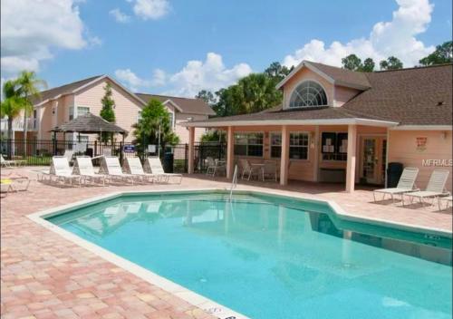 une piscine avec des chaises et une maison dans l'établissement The Royals Fully Stocked, Stylish, High Ratings, à Kissimmee