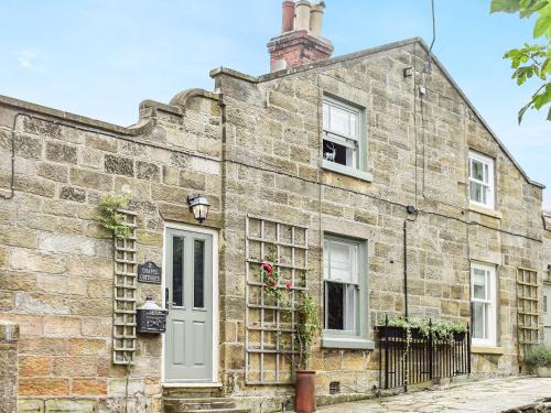 an old brick house with a white door and windows at Chapel Cottage in Robin Hood's Bay