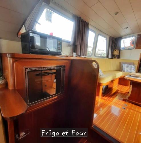 un salon avec une télévision sur le toit d'un bateau dans l'établissement Bateau le Zimon - logement insolite, à Rouen